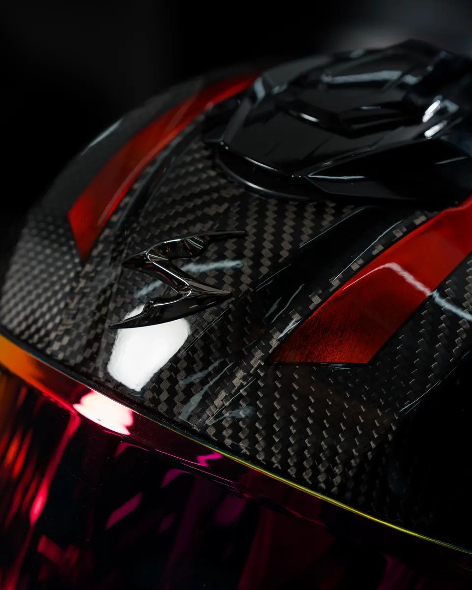 Close-up van de carbon kap van de Scorpion EXO-1500 Air met het Scorpion-logo en rode accenten
